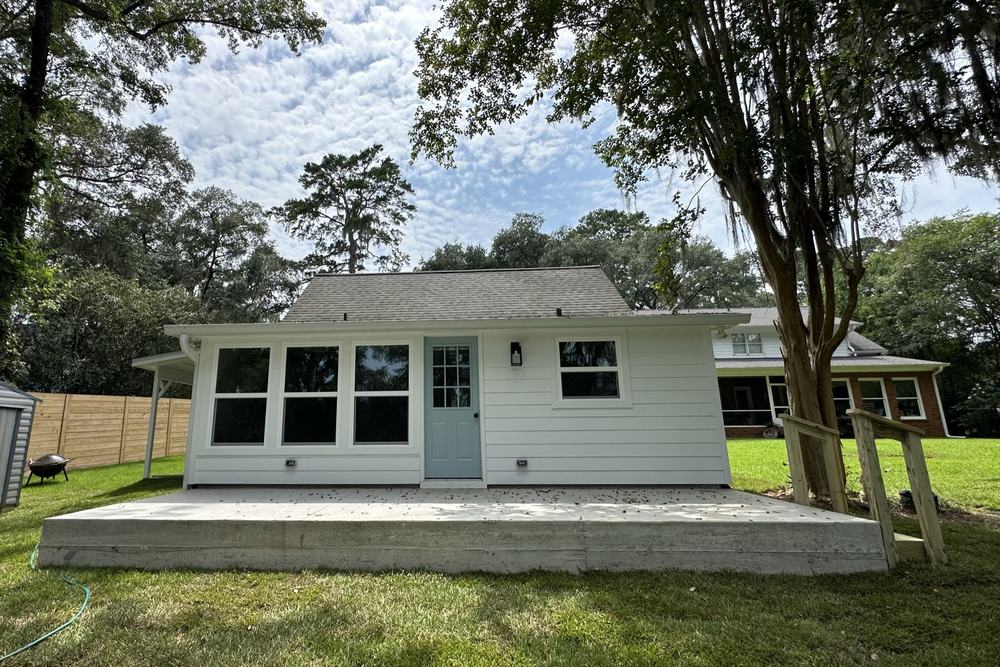 Rear elevation of a cottage ADU with a paved patio