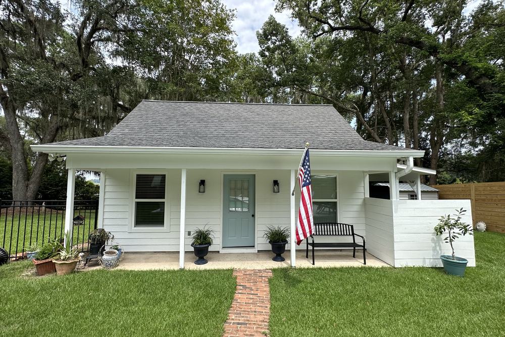 White cottage accessory dwelling unit with a covered front porch