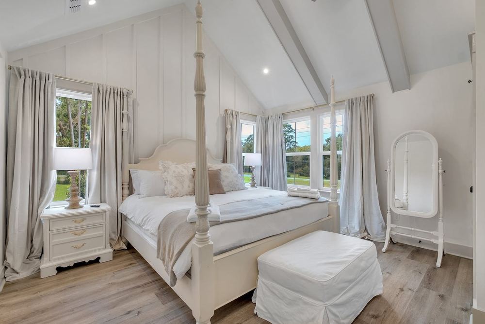 Primary bedroom with a four-poster bed under a vaulted ceiling