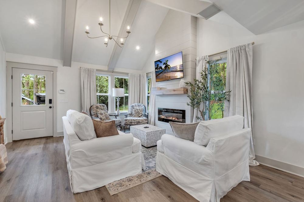 Vaulted living room with an exposed truss, linear fireplace and French doors