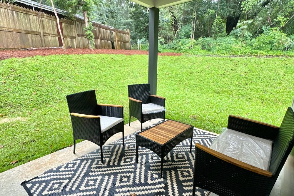 Covered rear porch with a ceiling fan and outdoor seating