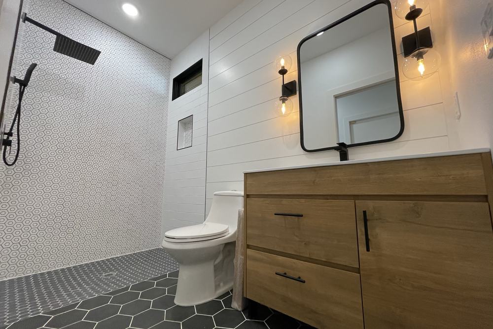 Second bathroom with a wood vanity, hexagon tile and black fixtures