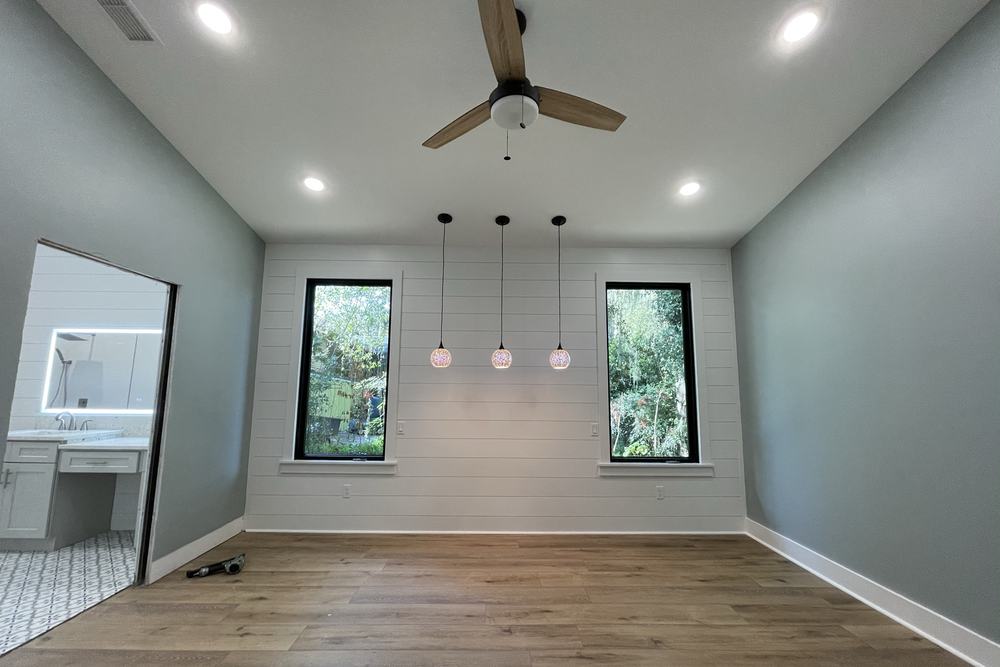 Primary bedroom with a vaulted ceiling and an ensuite bathroom beyond