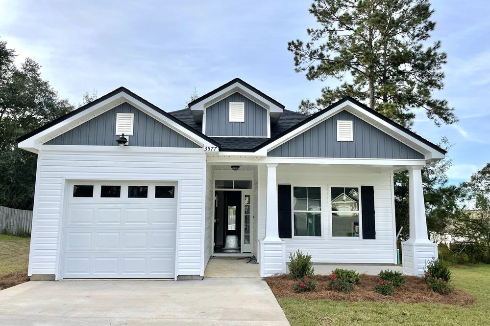 White and grey board-and-batten custom home with black trim built by JSR Construction