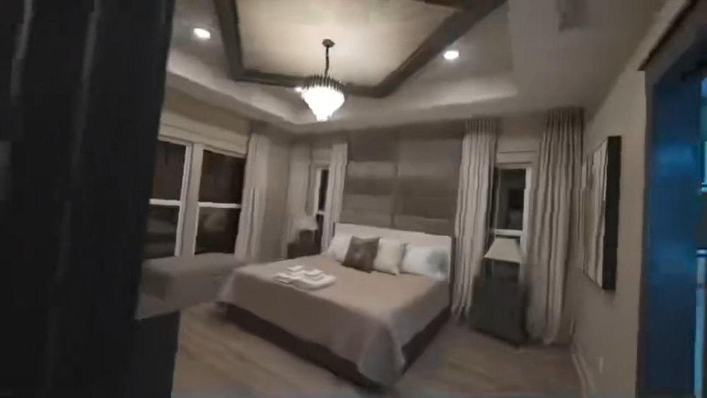 Primary bedroom with a tray ceiling and layered lighting