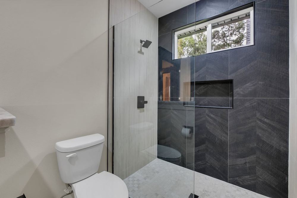 Bathroom with a dark tiled walk-in shower
