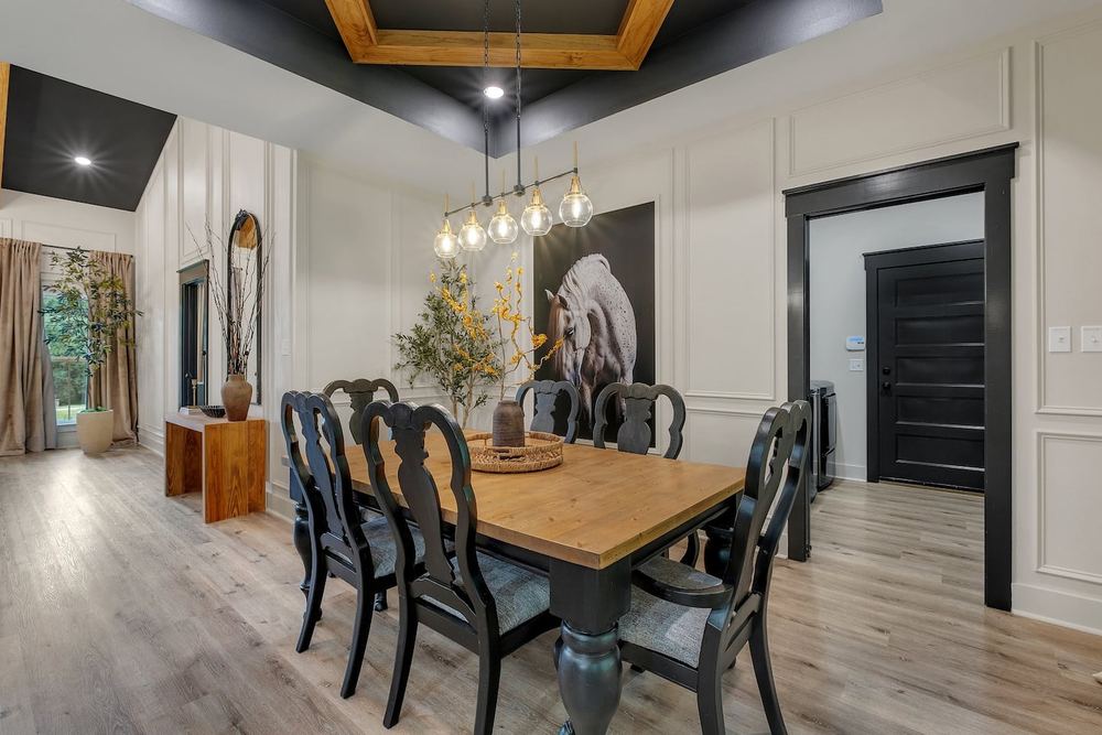 Dining room with a tray ceiling and a statement chandelier