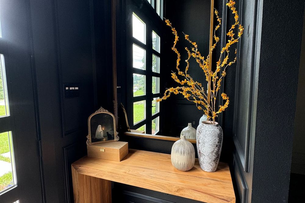 Entry vignette with a black panelled wall and an arched mirror