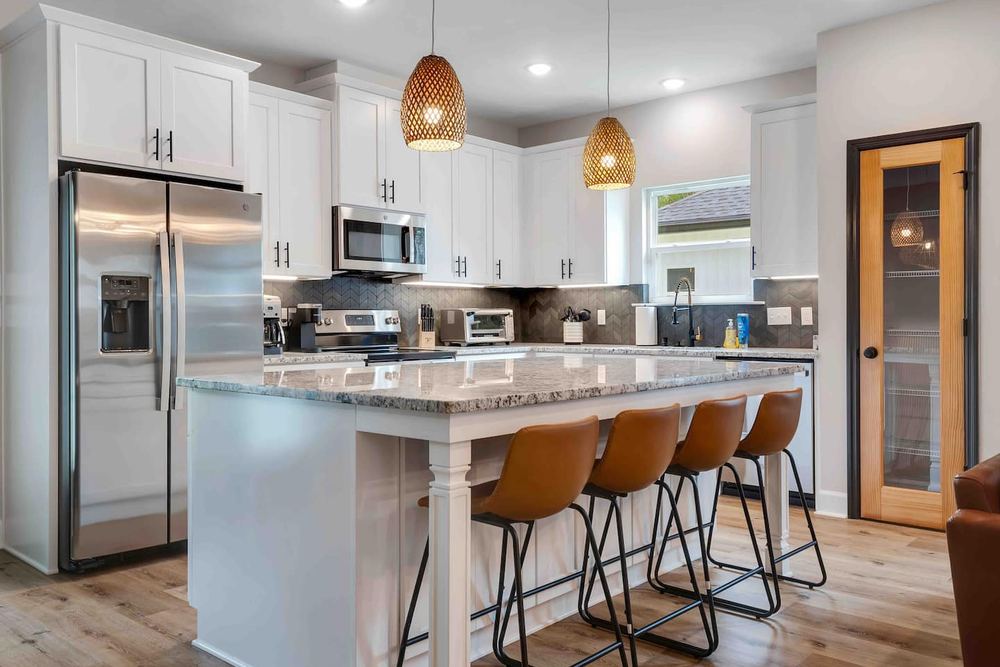 Kitchen with a granite island, bar seating and pendant lighting