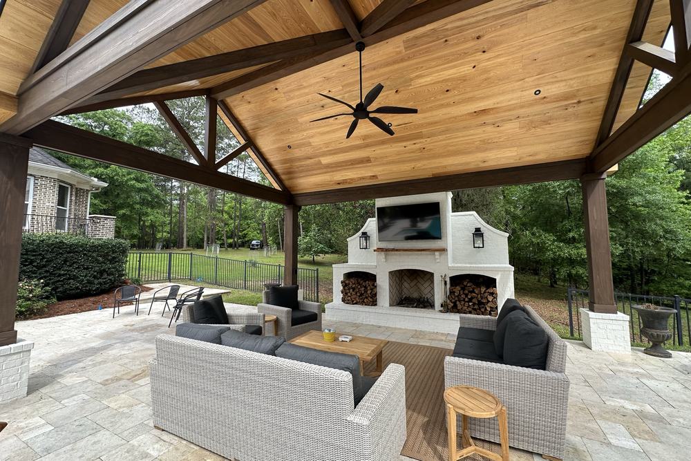 Outdoor fireplace with built-in seating under a covered pavilion