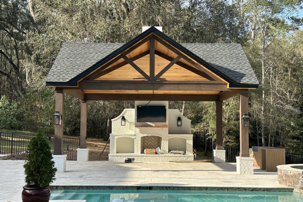 A cedar-truss pool pavilion built by JSR Construction, seen across the pool